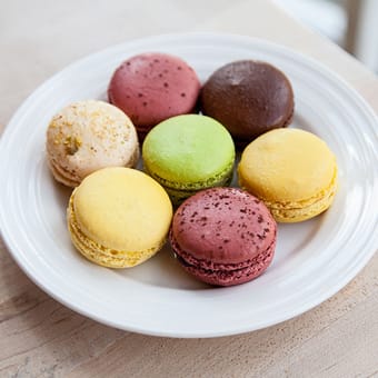 Plate of assorted French macarons in pistachio, raspberry, chocolate, and lemon