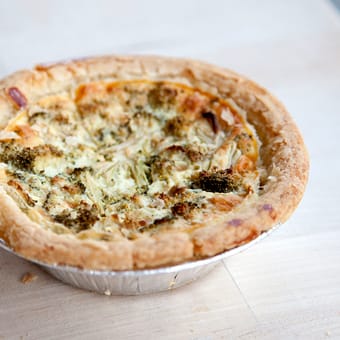 Golden-crusted broccoli and cheese quiche in a foil baking tin